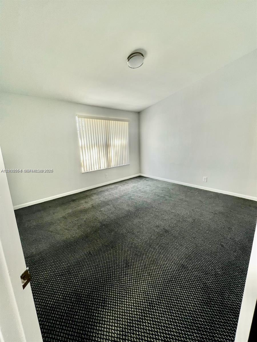 Room featuring dark wall-to-wall carpeting, neutral-toned walls, and a recessed ceiling light fixture