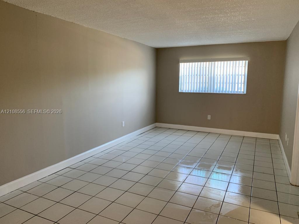 Interior space featuring light-toned tile flooring and neutral wall paint Interior space featuring light-toned tile flooring and neutral wall paint