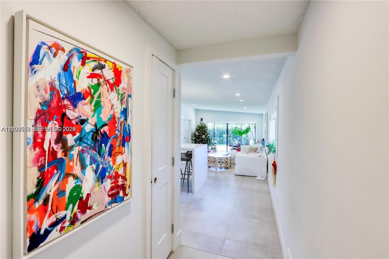 Neutral wall palette with large-format tile flooring, recessed ceiling lighting, and solid-core interior doors