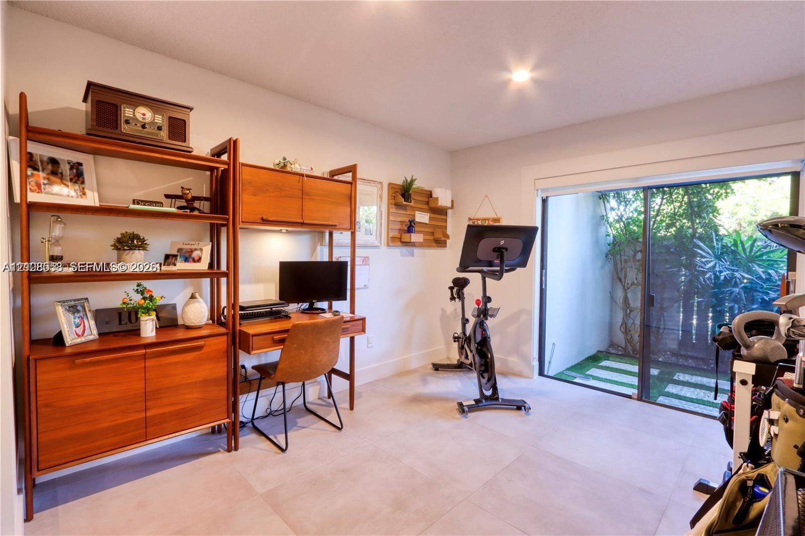 Room featuring large-format tile flooring and sliding glass doors with access to an exterior paved area