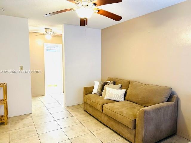 Neutral wall finish, large-format ceramic tile flooring, and dual ceiling fans with integrated lighting fixtures
