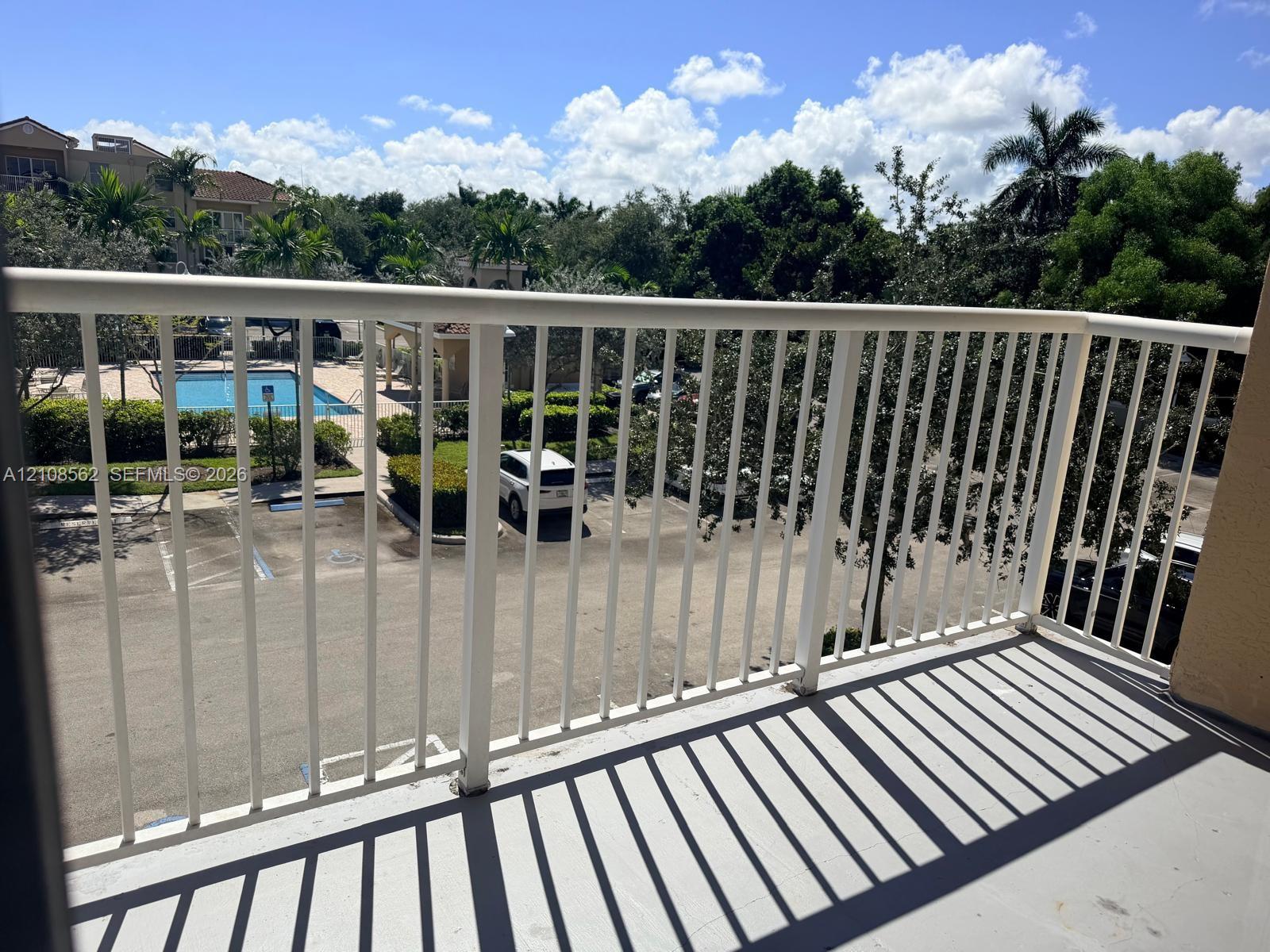 Private balcony with white metal railings and concrete flooring