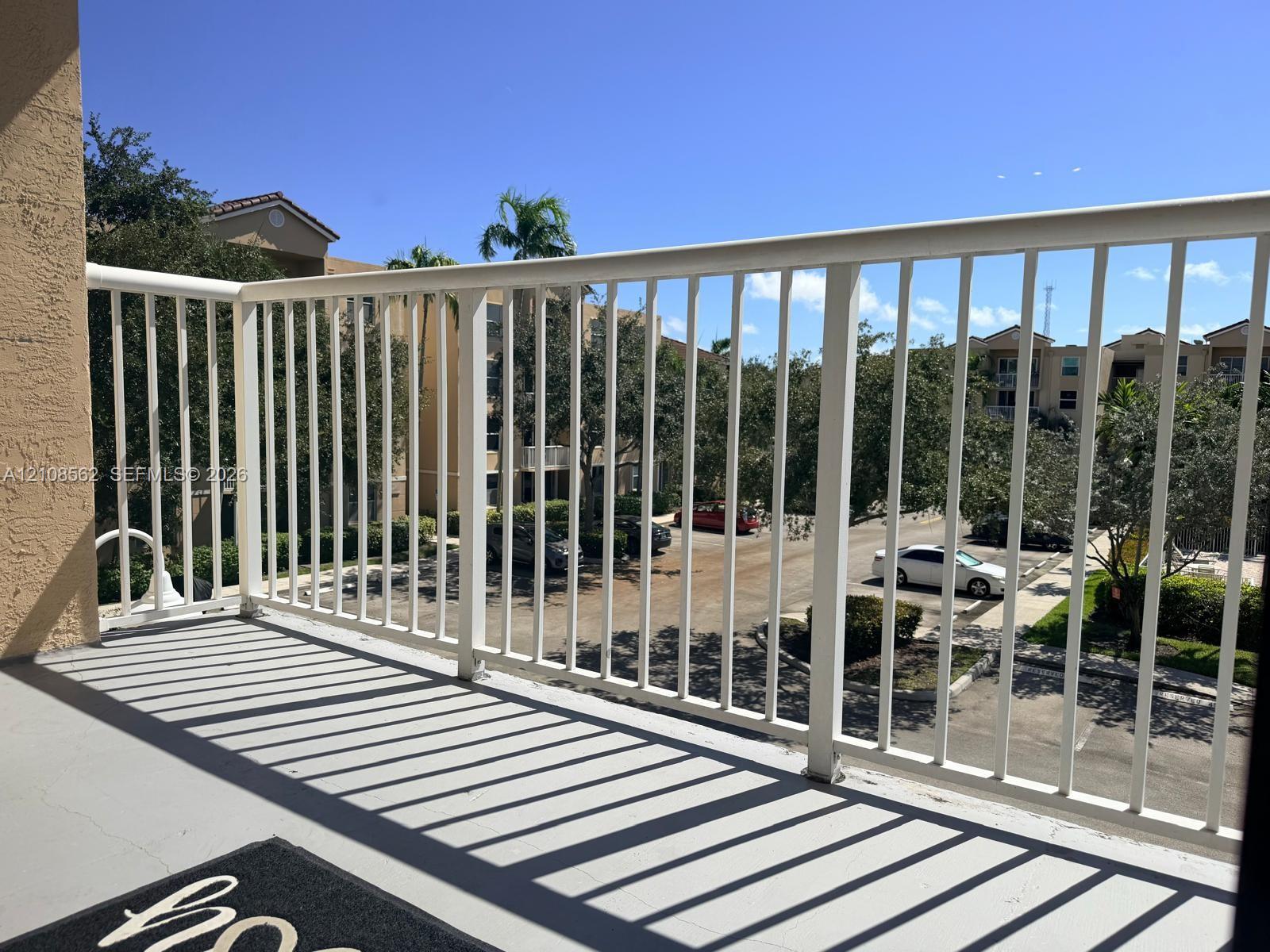 Private balcony featuring white vertical railing and concrete flooring