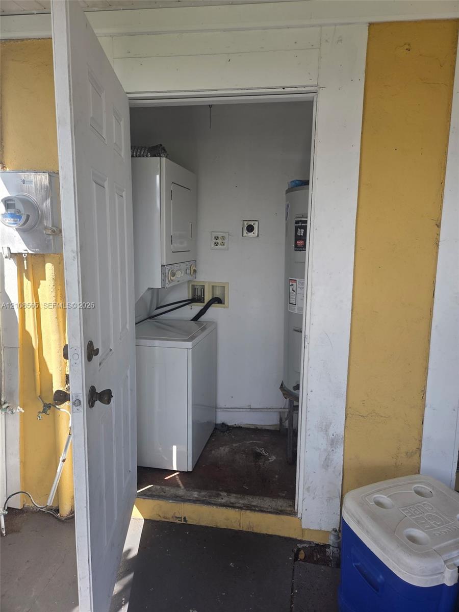 Utility area featuring a stacked laundry unit and a dedicated water heater