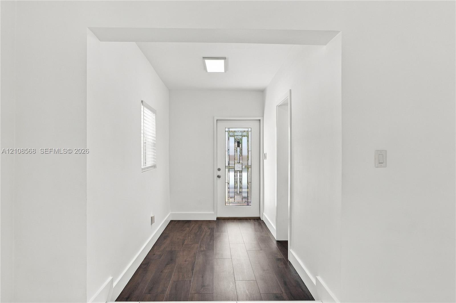 Entryway featuring wood-finish flooring, a recessed ceiling light, and an exterior door with decorative glass paneling