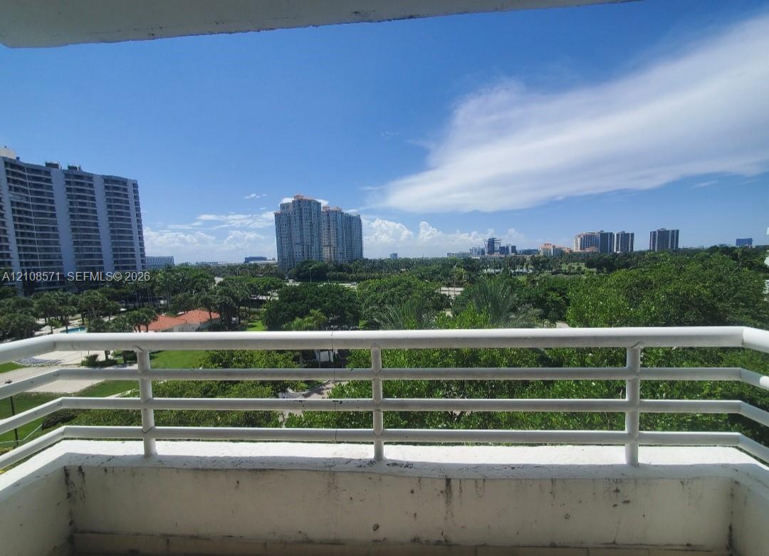 Private balcony featuring a white metal railing and a concrete base