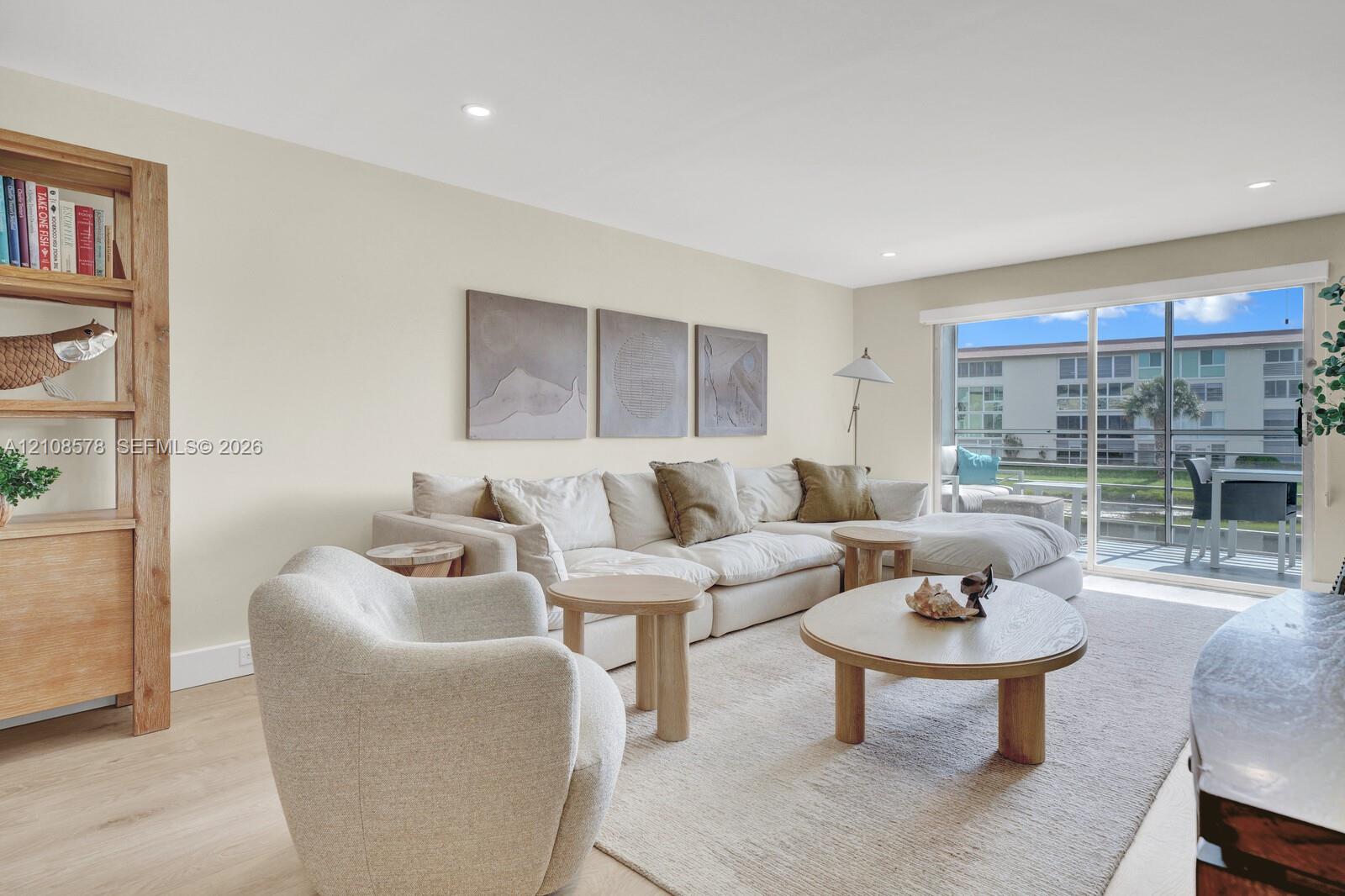 Neutral wall palette featuring wood-finish flooring, recessed lighting, and large sliding glass doors providing outdoor access