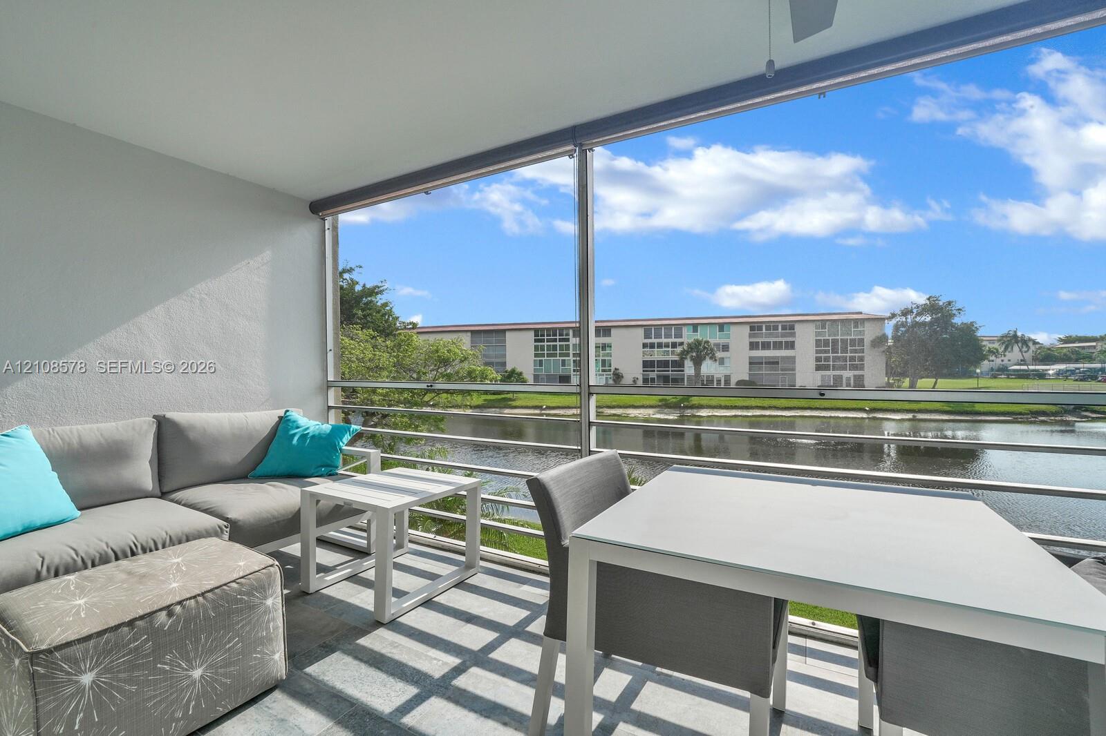 Screened-in balcony featuring tile flooring, metal railings, and a ceiling fan