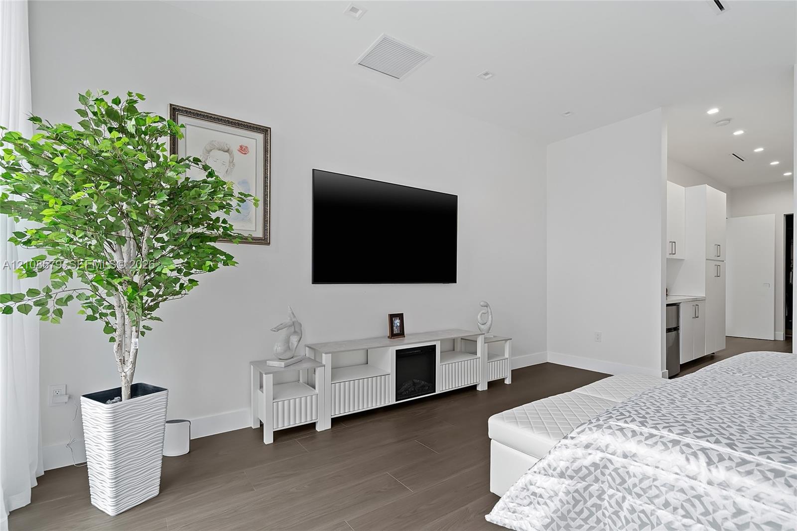 Wood-finish flooring, recessed ceiling lighting, and smooth white wall finishes