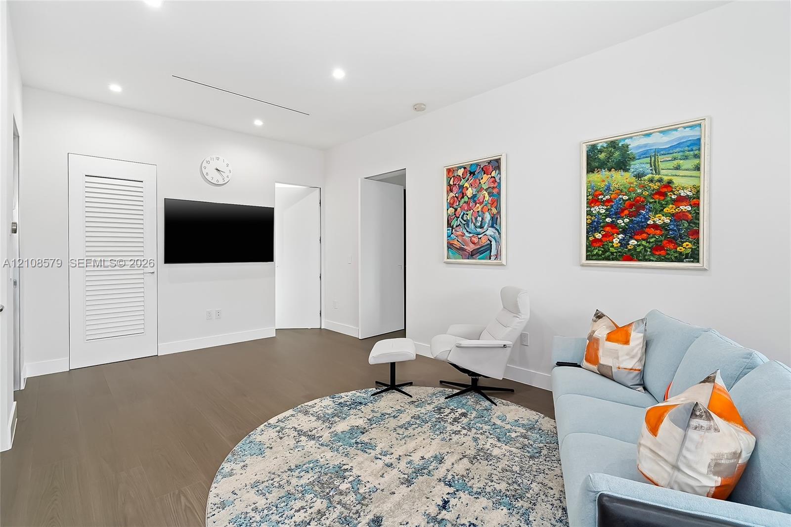 Neutral-toned interior featuring wood-finish flooring, recessed lighting, and a louvered-panel door