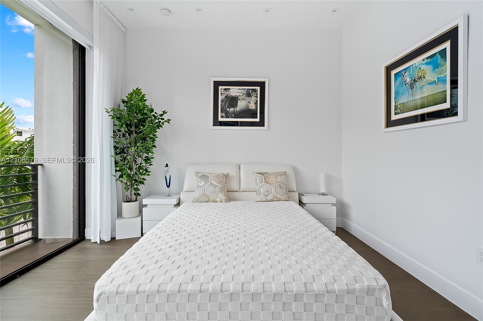 Floor-to-ceiling sliding glass door, wood-finish flooring, and recessed ceiling lighting