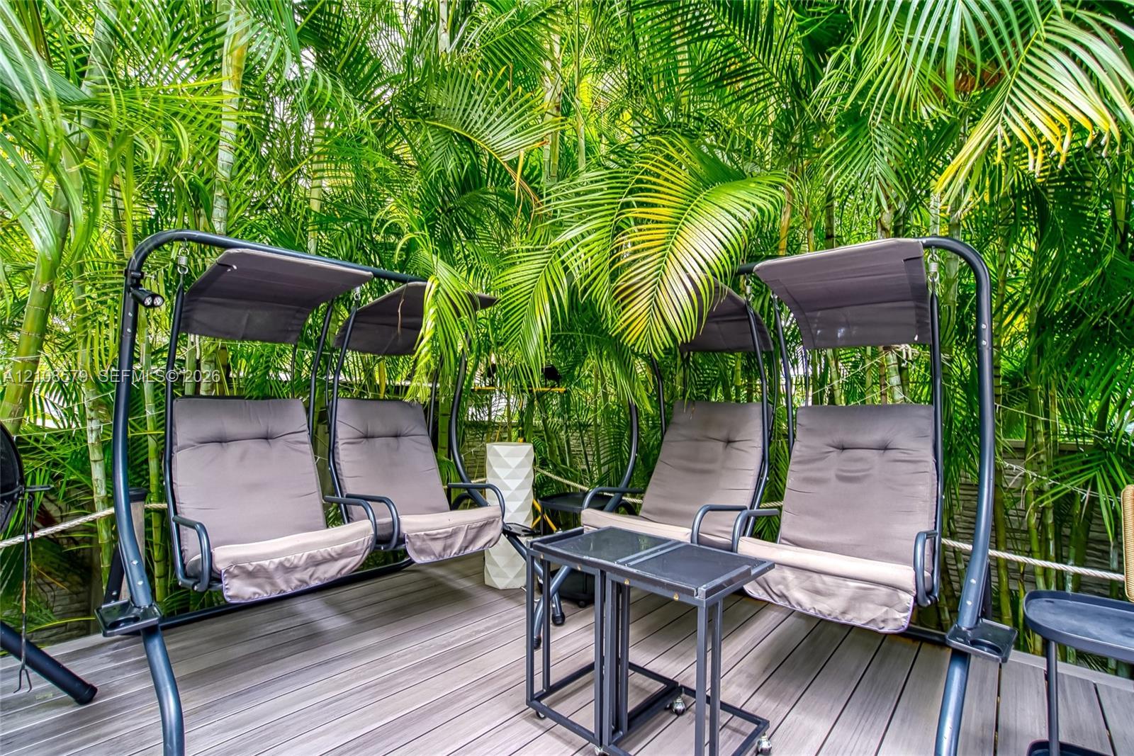 Outdoor deck featuring composite decking planks and mature palm trees