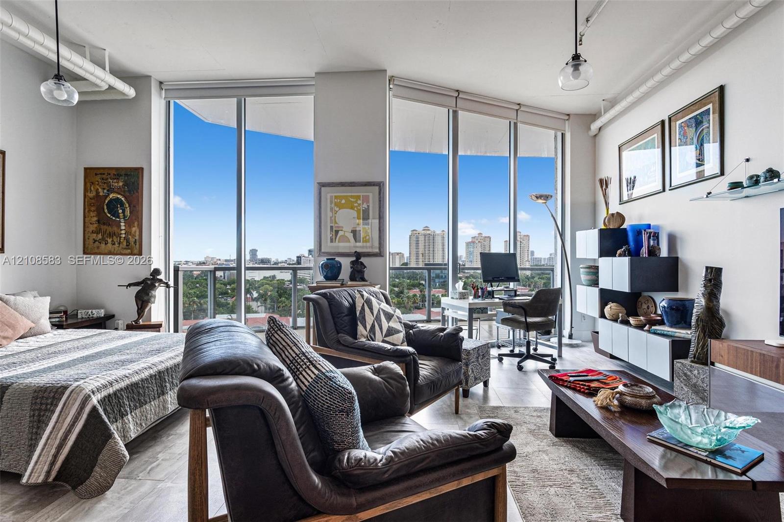 Floor-to-ceiling windows, wood-finish flooring, exposed white overhead piping, and modern pendant lighting Floor-to-ceiling windows, wood-finish flooring, exposed white overhead piping, and modern pendant lighting