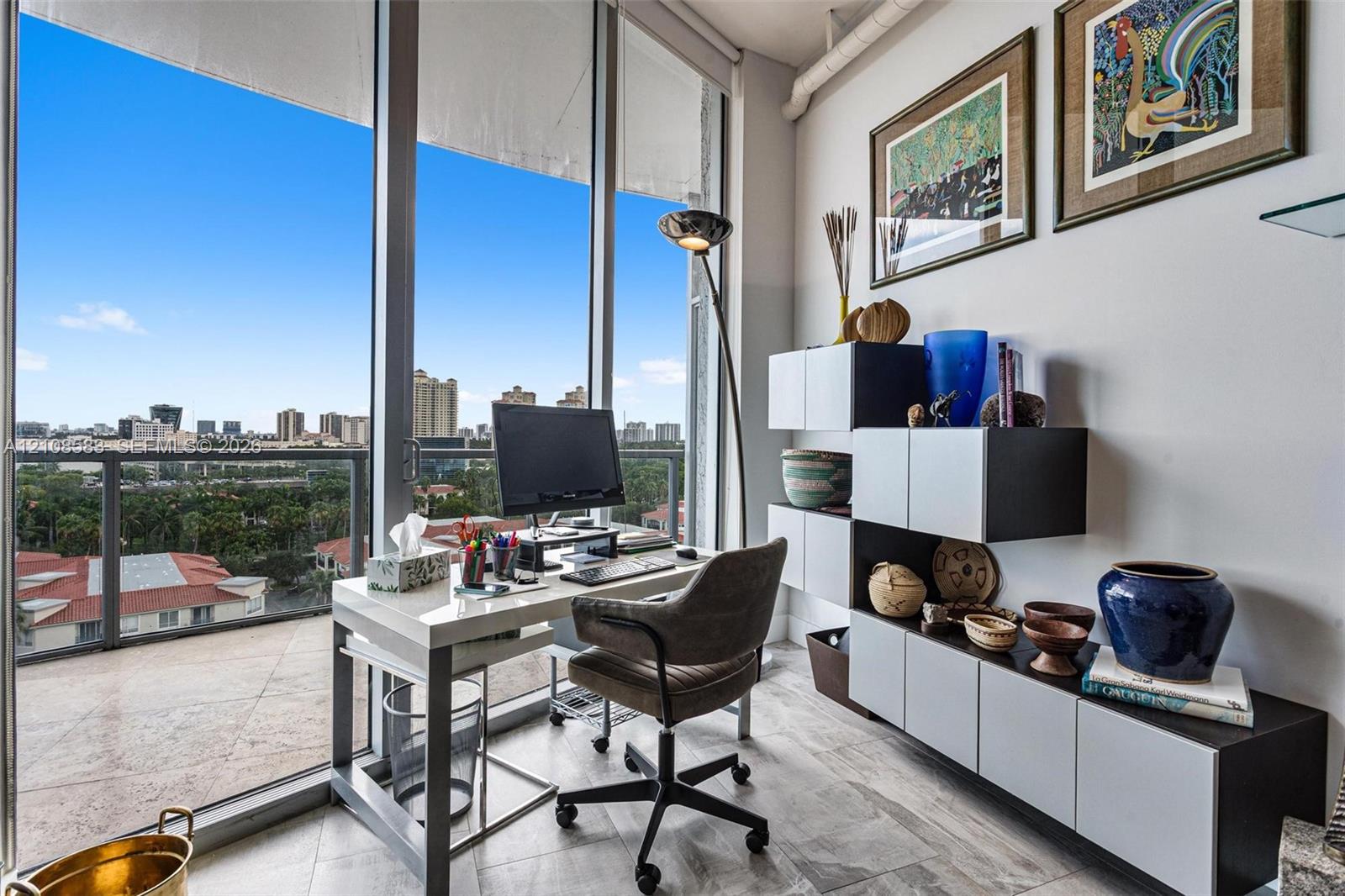 Floor-to-ceiling windows, tile flooring, and a glass-railed private balcony