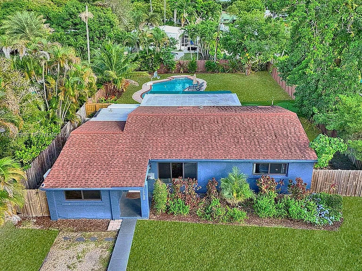 Single-story residence featuring a shingled roof, stucco exterior, rear swimming pool, and wood-paneled privacy fencing Single-story residence featuring a shingled roof, stucco exterior, rear swimming pool, and wood-paneled privacy fencing