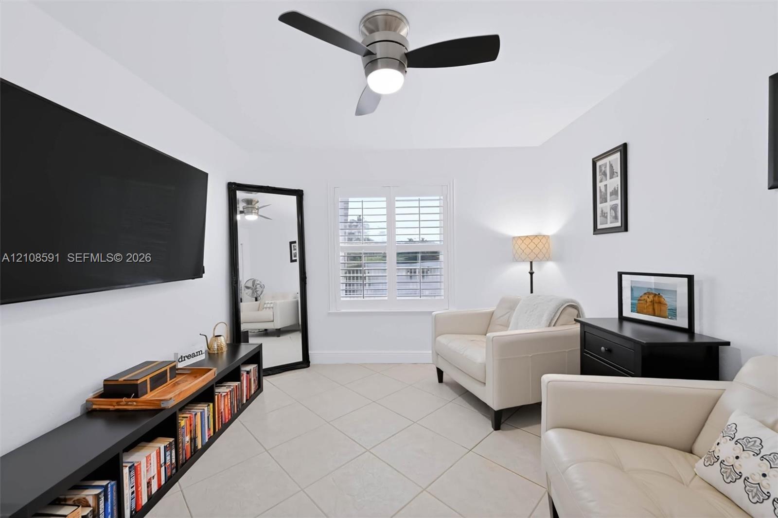 Room featuring diagonal-set ceramic tile flooring, plantation shutters, and a brushed nickel ceiling fan with integrated lighting