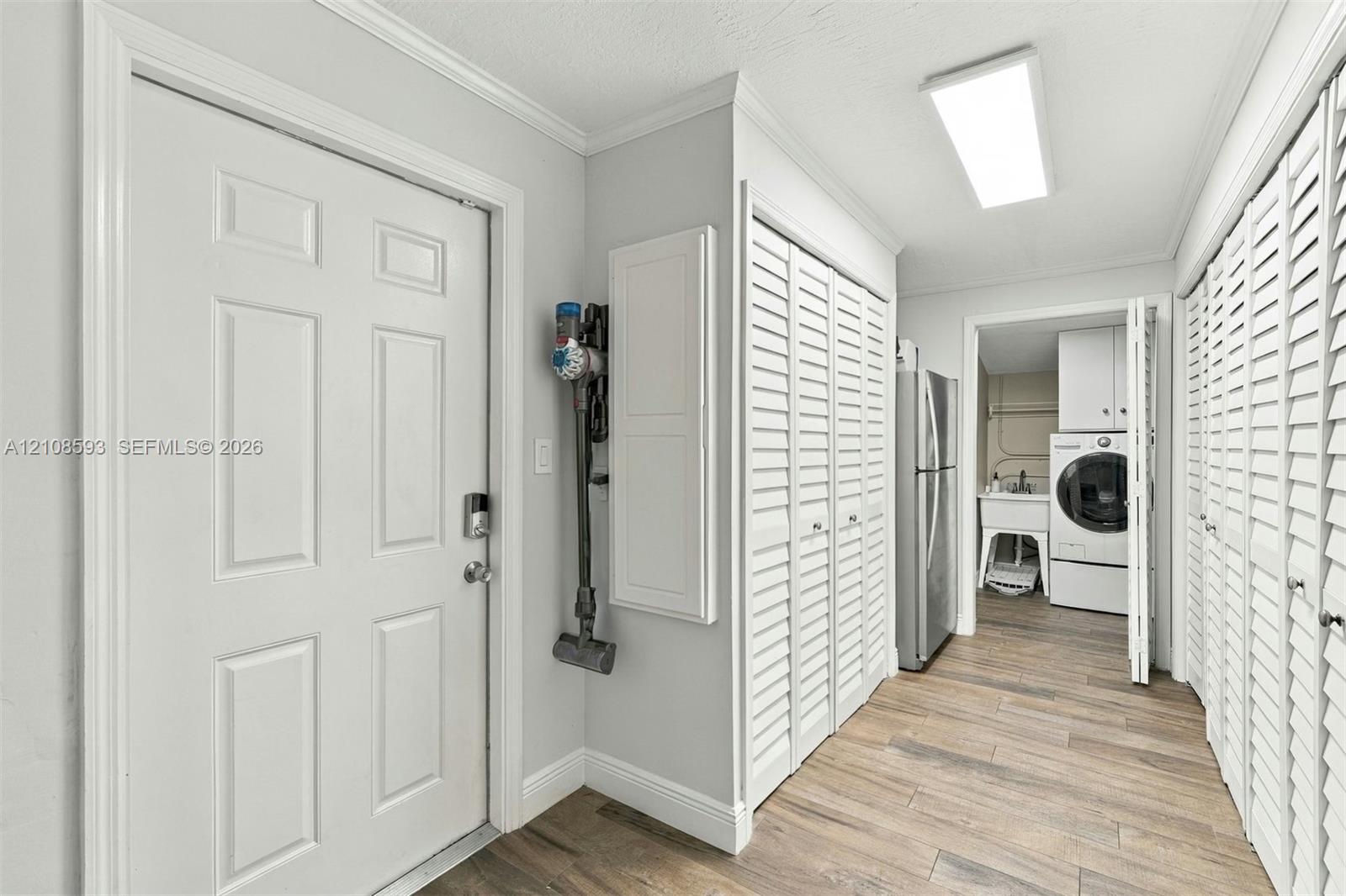 Utility area featuring wood-finish flooring, dual sets of louvered closet doors, and recessed lighting