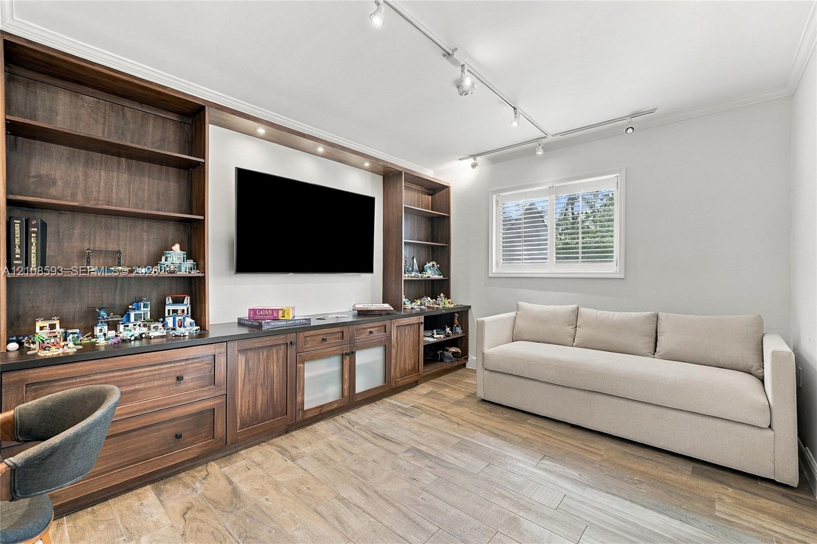 Built-in wall-to-wall cabinetry featuring dark wood finish, open shelving, lower storage drawers, and recessed lighting, finished with wood-finish flooring and adjustable ceiling-mounted track lighting