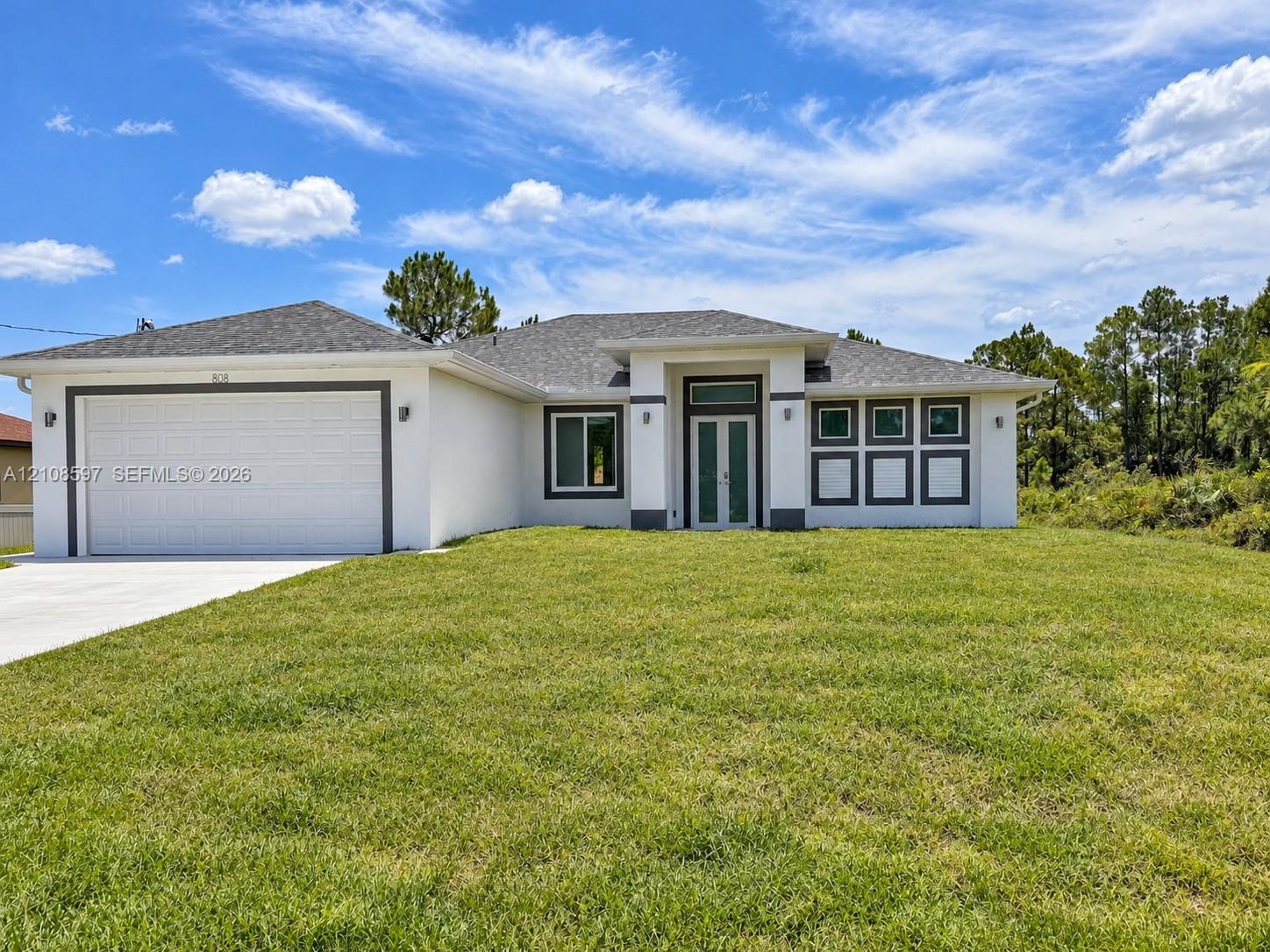 Stucco exterior featuring a dual-car garage, recessed entryway with a glass-paneled front door, transom window, and architectural shingle roofing Stucco exterior featuring a dual-car garage, recessed entryway with a glass-paneled front door, transom window, and architectural shingle roofing