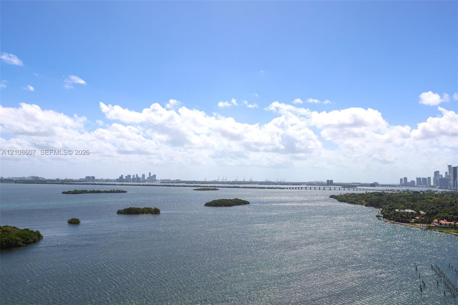 Panoramic bay waterscape featuring coastal islands, distant cityscape skyline, and bridge infrastructure