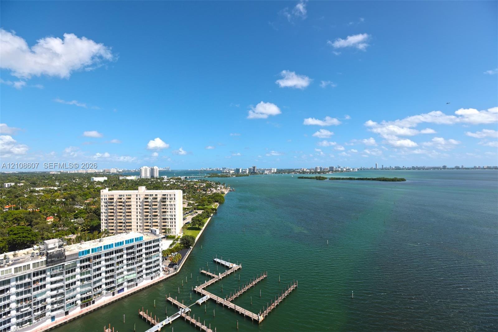 Elevated waterfront perspective featuring expansive coastal scenery, deep-water bay access, and a multi-slip private dock structure