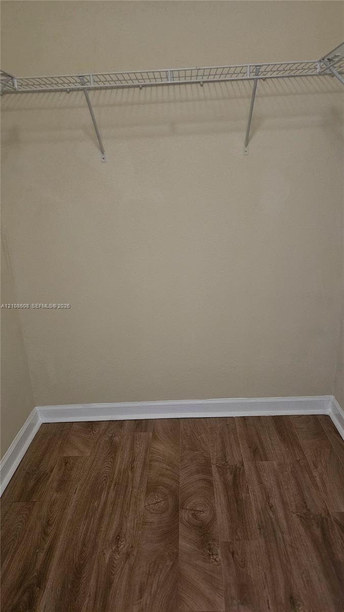Walk-in closet featuring wire shelving and wood-finish flooring