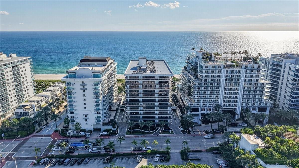 Coastal high-rise buildings featuring expansive glass-railed balconies and direct oceanfront positioning