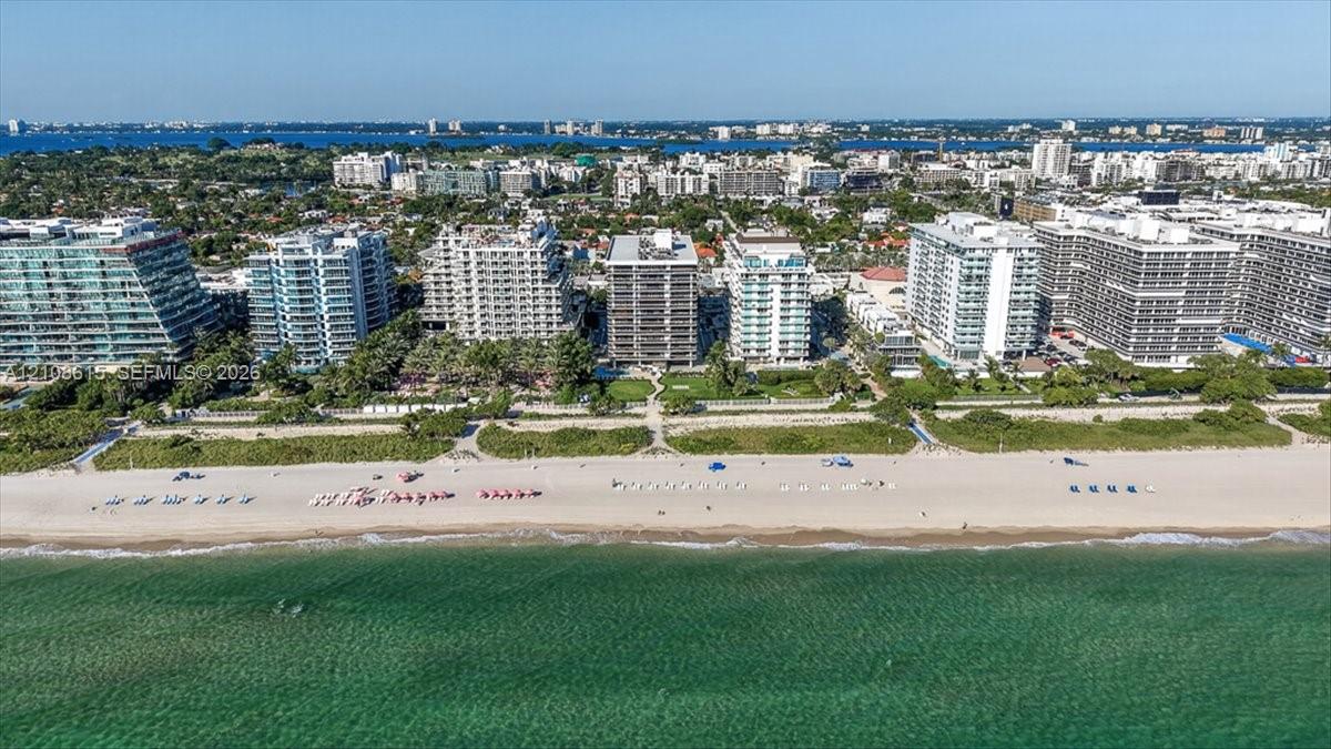 Aerial perspective of coastal high-rise properties featuring direct beach access, sandy shoreline, and proximity to ocean waters