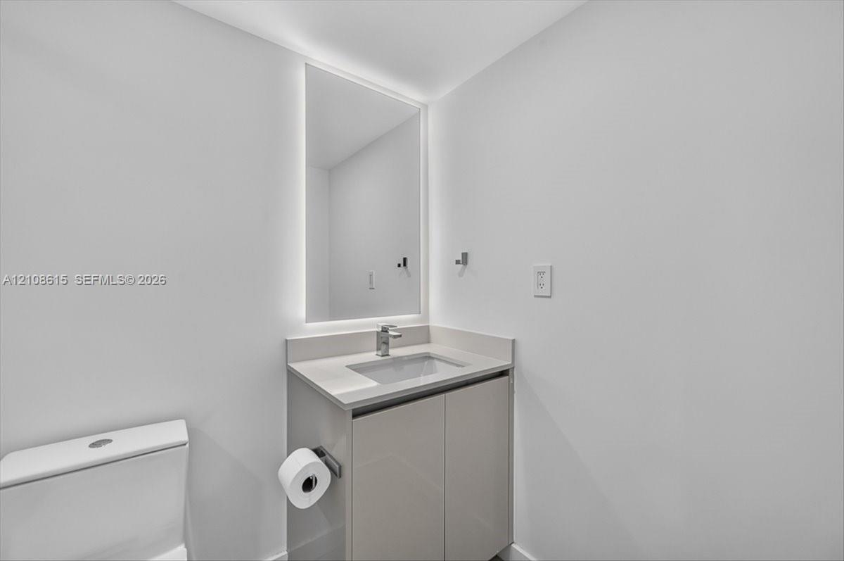 Modern vanity with a countertop basin, LED-backlit mirror, and chrome faucet fixture