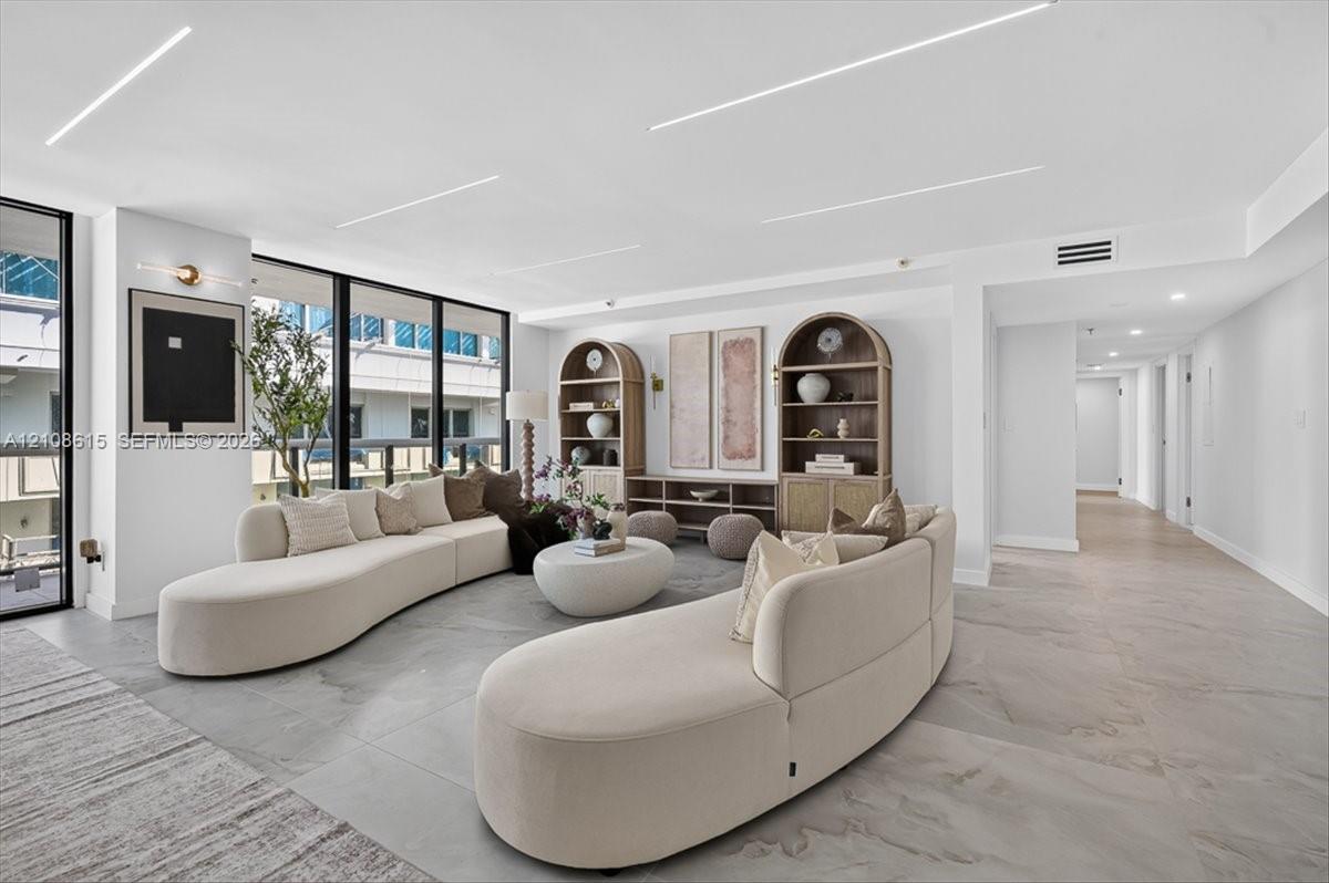 Open-concept interior featuring large-format tile flooring, floor-to-ceiling windows, and recessed linear LED lighting