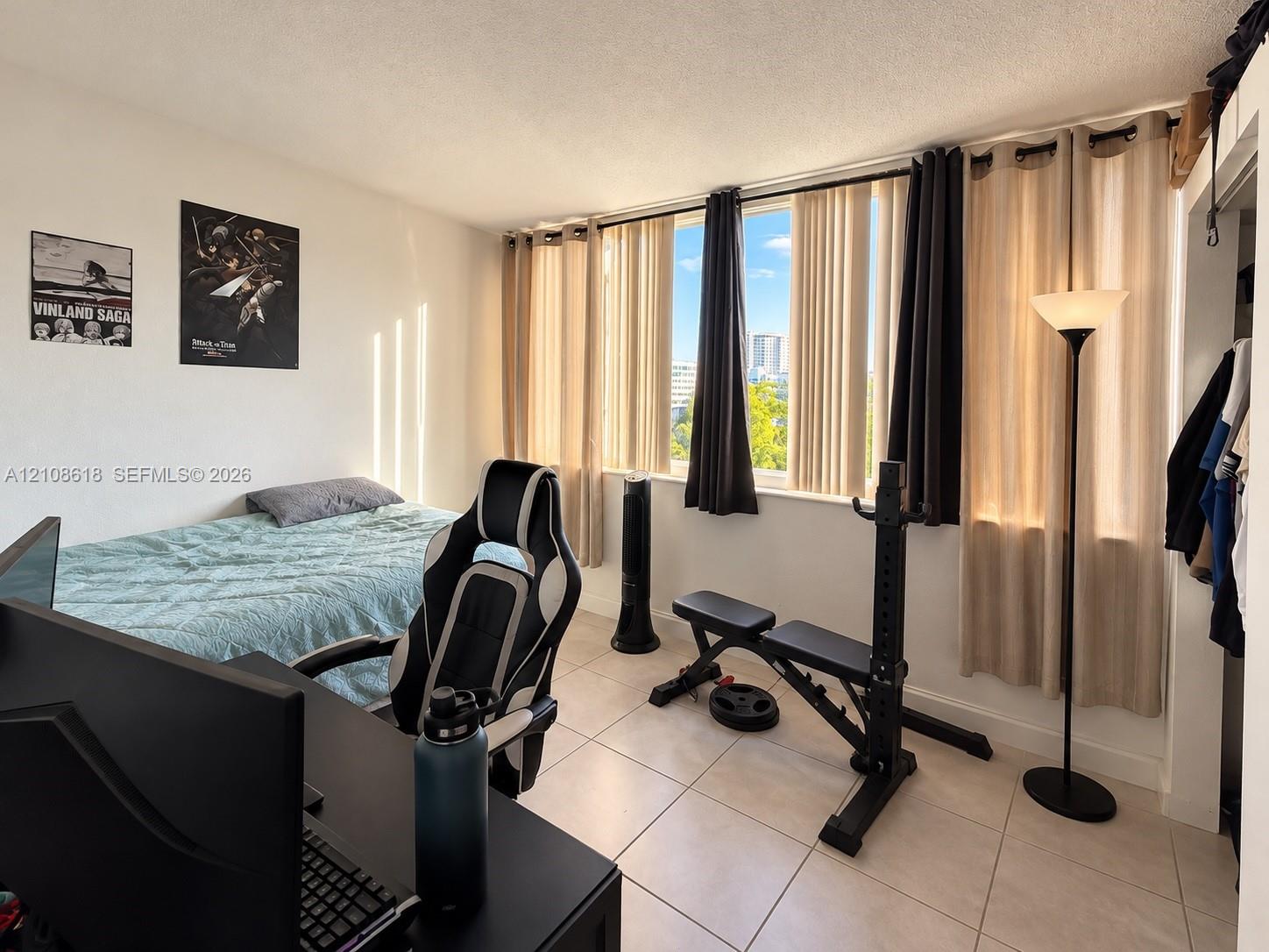 Room featuring large, floor-to-ceiling windows, ceramic tile flooring, and a built-in closet