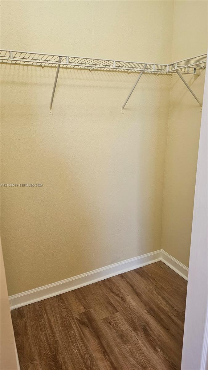 Storage closet featuring wood-finish flooring and integrated wire shelving