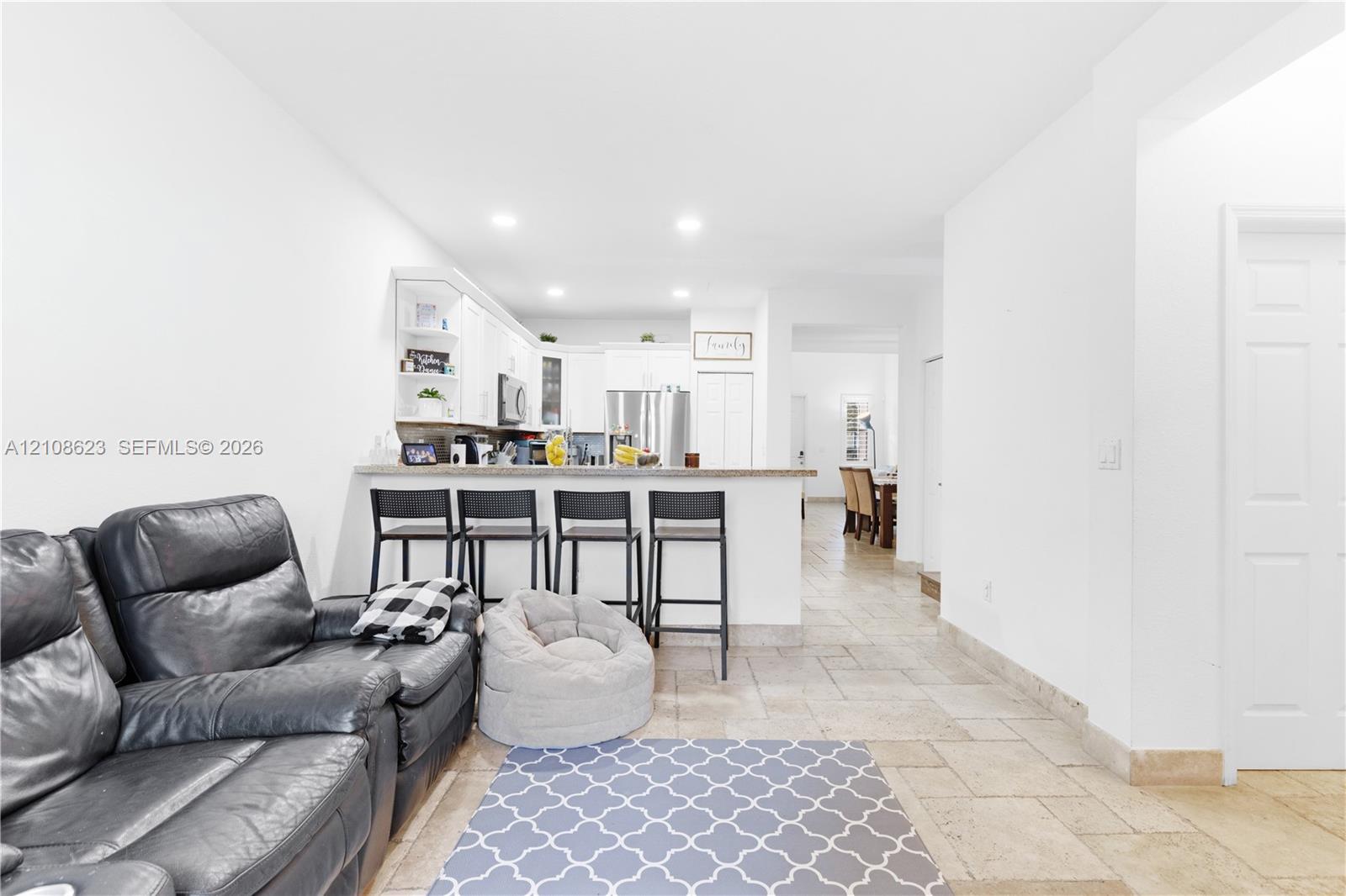 Kitchen featuring white cabinetry, a stone-finish countertop, stainless steel appliances, recessed lighting, and tile flooring