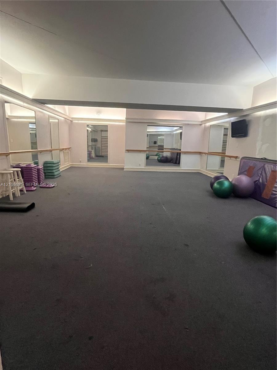 Spacious interior featuring full-length wall mirrors, integrated recessed lighting, and wall-mounted wooden ballet barres