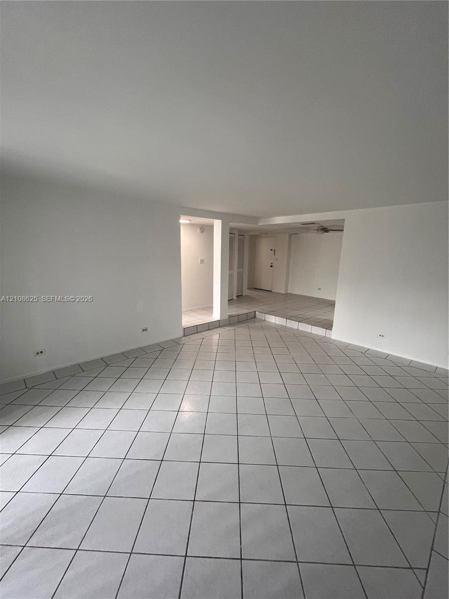 Open interior space featuring neutral ceramic tile flooring and multi-level floor plan with recessed structural partitions