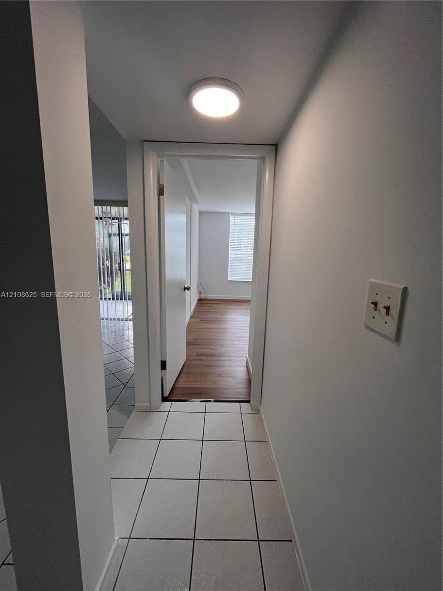 Ceramic tile flooring, flush-mount ceiling lighting, and wood-finish flooring