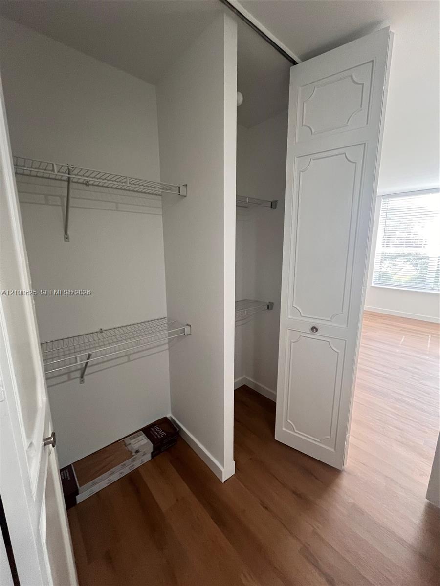 Walk-in closet featuring white paneled bi-fold doors, white interior walls, and multi-level wire shelving