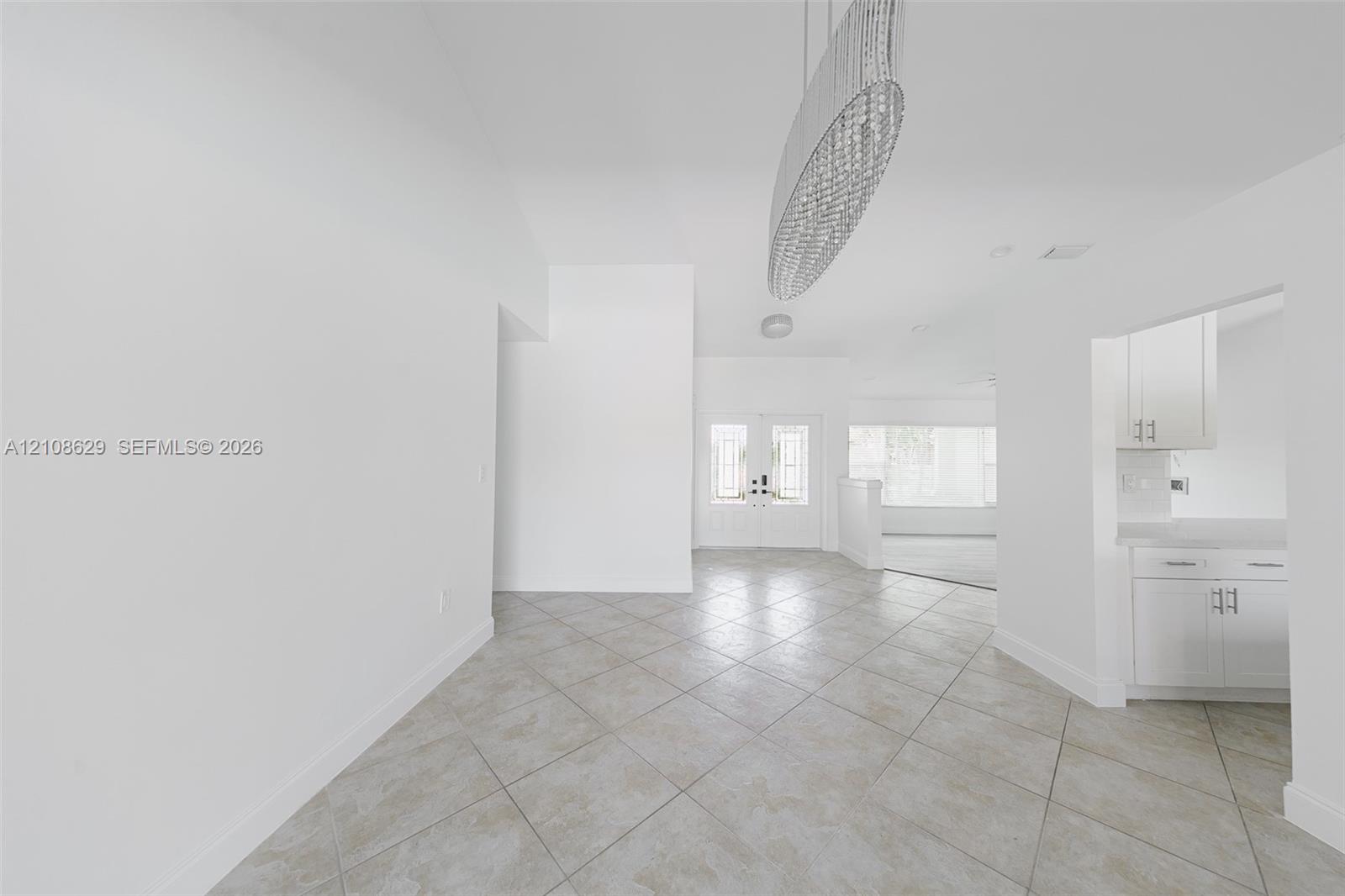 Open-concept foyer featuring diagonal-set tile flooring, recessed lighting, and a modern tiered crystal pendant fixture