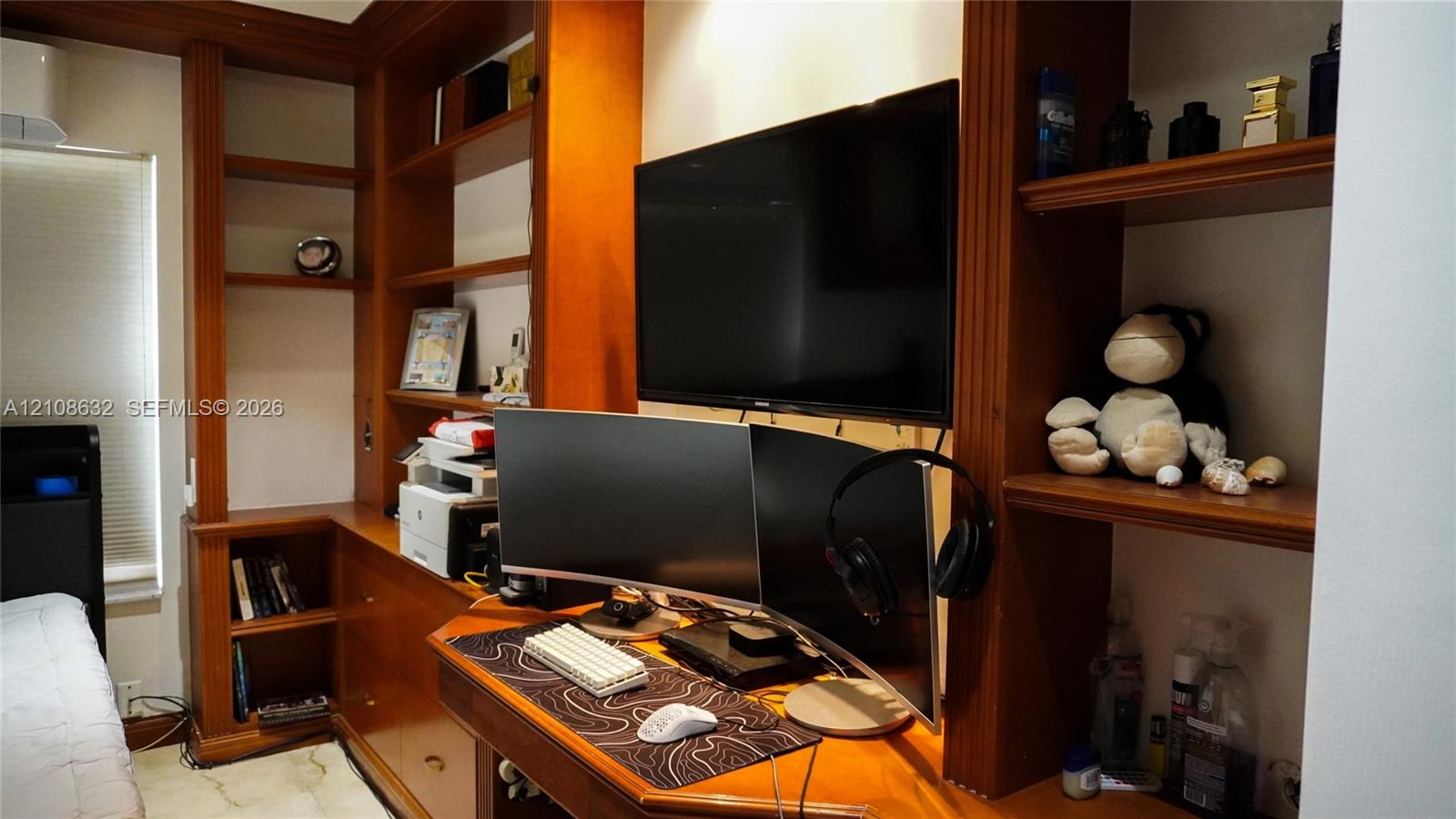 Custom built-in wood cabinetry featuring extensive shelving, integrated desk surface, and lower storage drawers
