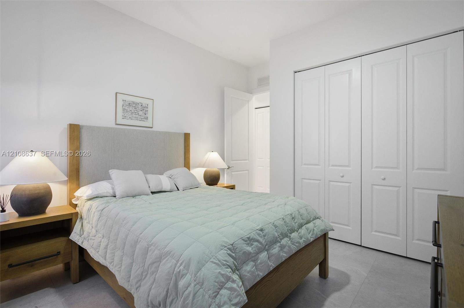 Room featuring neutral wall tones, large format tile flooring, and a floor-to-ceiling closet with white paneled bi-fold doors