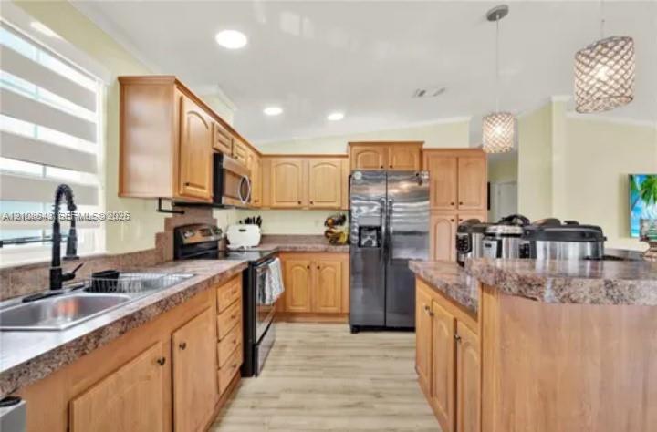 Kitchen featuring wood cabinetry, stone-finish countertops, stainless steel appliances, wood-finish flooring, and pendant lighting