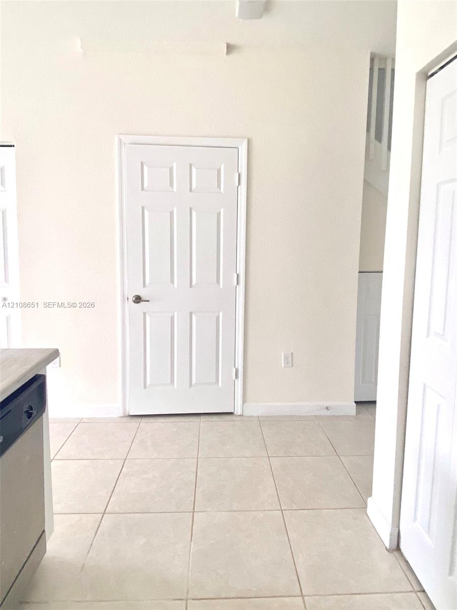 Neutral-toned tile flooring, six-panel interior doors, and clean-finished walls