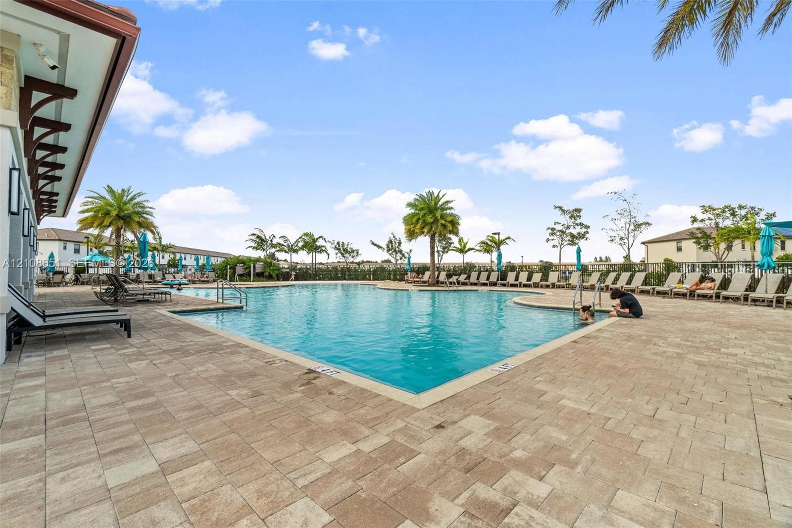 In-ground swimming pool with a stone paver deck and perimeter landscaping