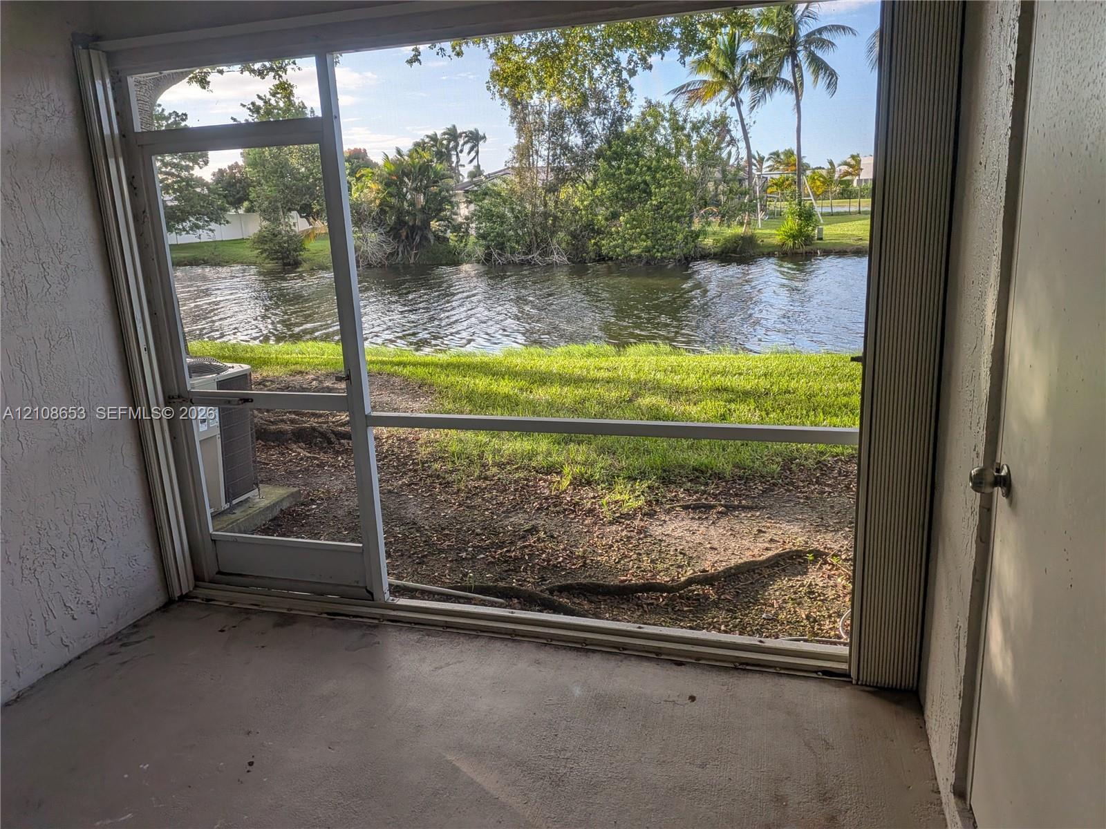 Enclosed porch featuring a screen frame, concrete flooring, and water frontage Enclosed porch featuring a screen frame, concrete flooring, and water frontage