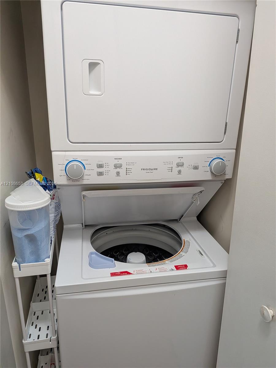Stacked Frigidaire laundry unit featuring a white top-loading washer and integrated dryer