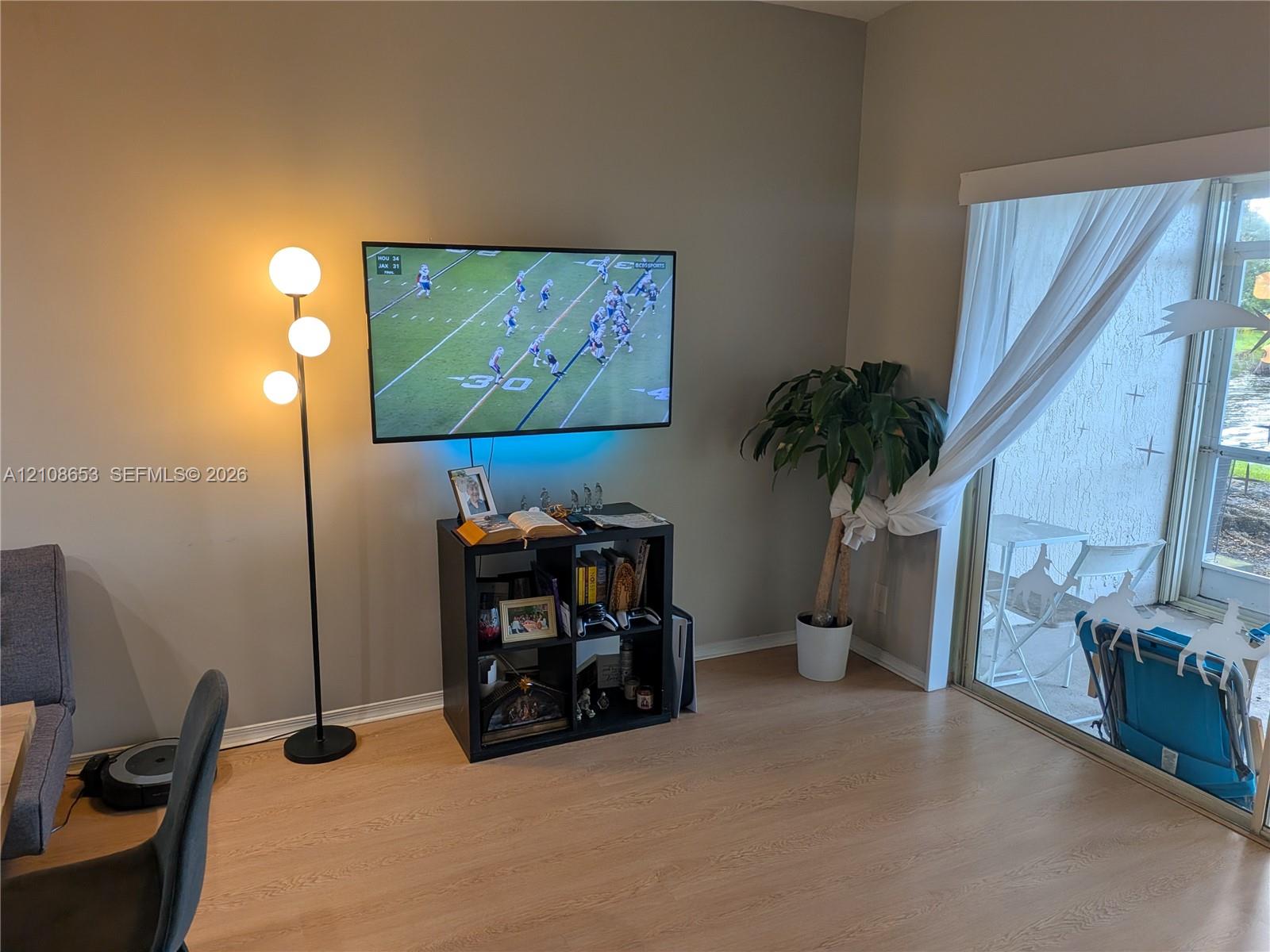 Wood-finish flooring and sliding glass door leading to an outdoor space Wood-finish flooring and sliding glass door leading to an outdoor space