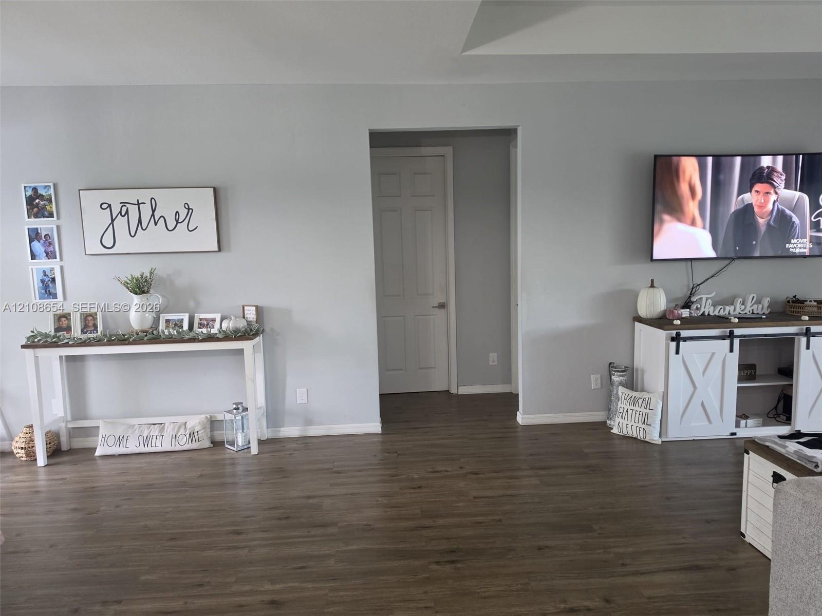 Neutral-toned walls paired with wood-finish flooring and a central six-panel interior door