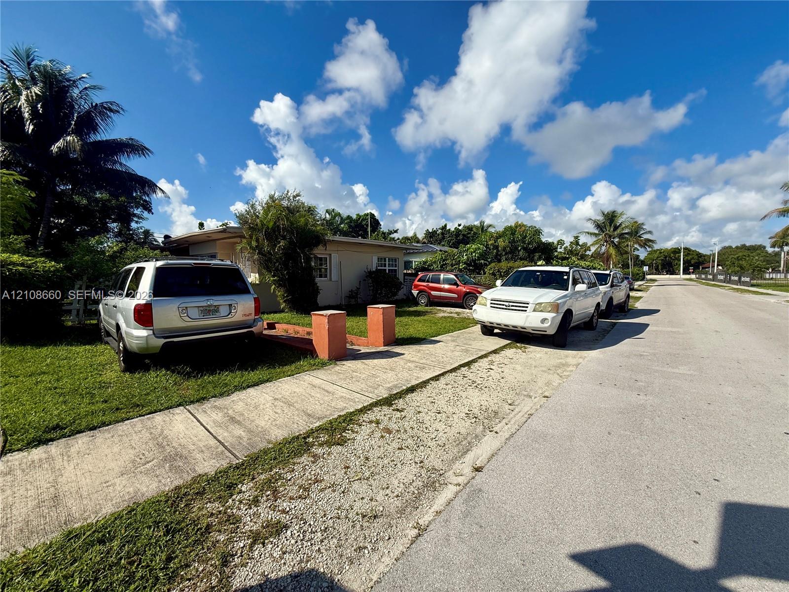 Single-story exterior with a low-pitched roof, concrete driveway, and established landscaping