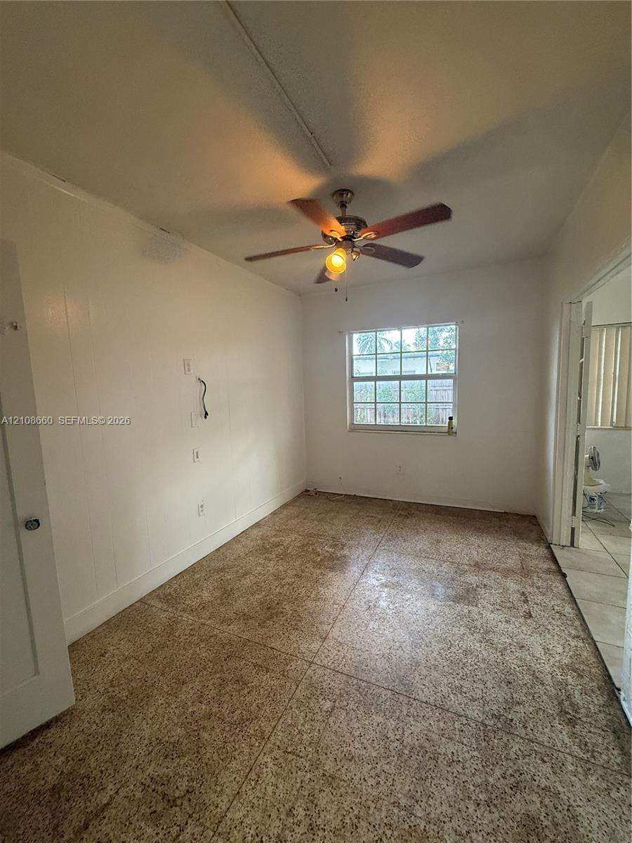 Interior space featuring tile flooring, a multi-blade ceiling fan with integrated lighting, and a single-pane window