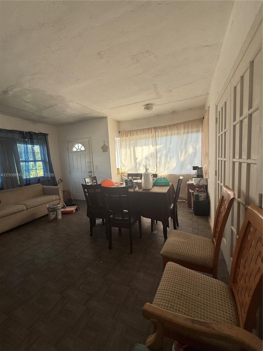 Interior space featuring square-pattern tile flooring, large windows, and multi-pane glass doors Interior space featuring square-pattern tile flooring, large windows, and multi-pane glass doors
